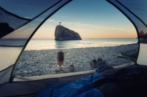 A view of the rock of the holy phenomenon from the tent on the beach at dawn. Crimea